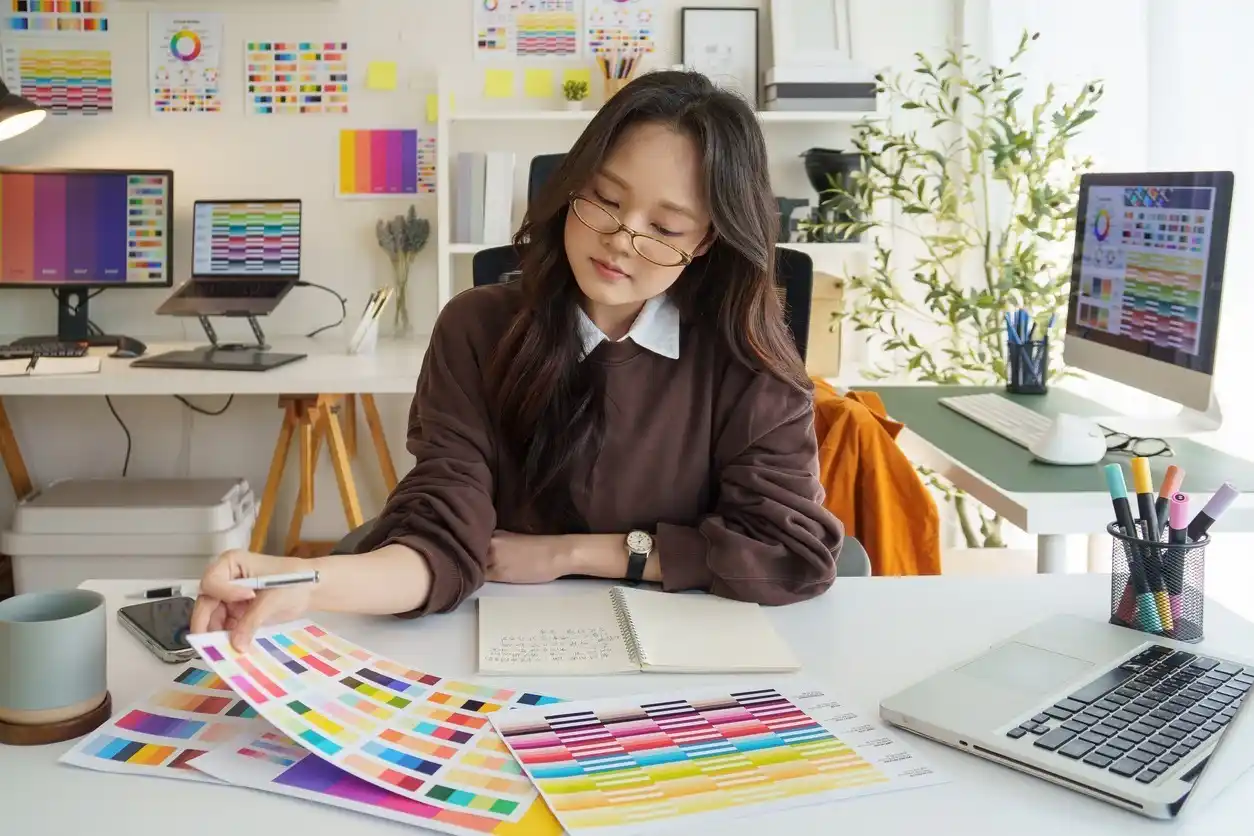 Graphic designer reviewing color samples for design project in creative office.